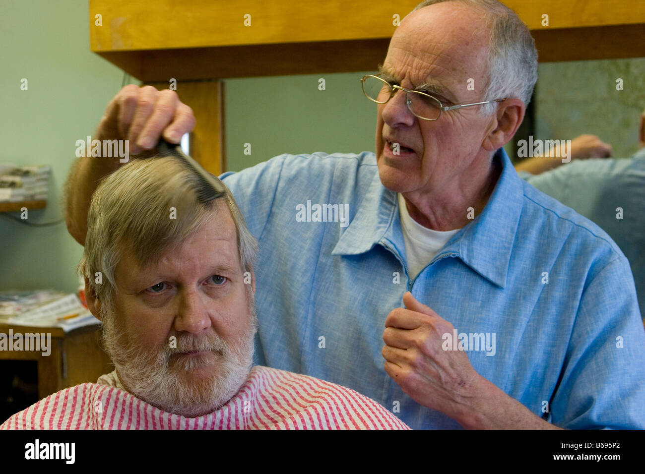 Barber cutting a man's hair in barber shop Stock Photo Alamy