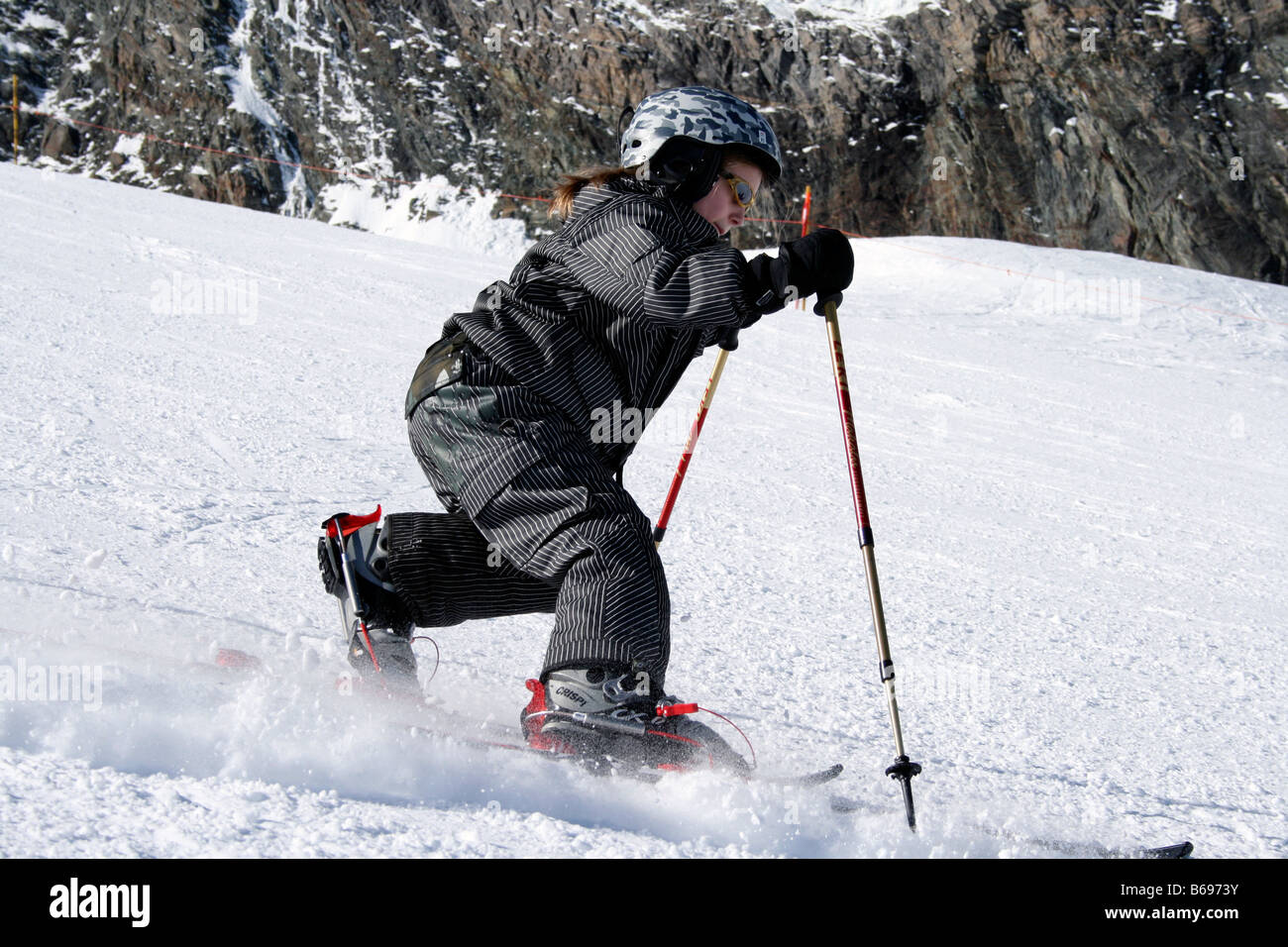 Nine year old girl skiing in Telemark style on the slopes of Saas Fee, Swiss, Europe Stock Photo