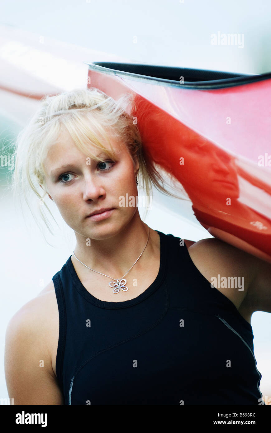 Young woman carrying kayak Stock Photo