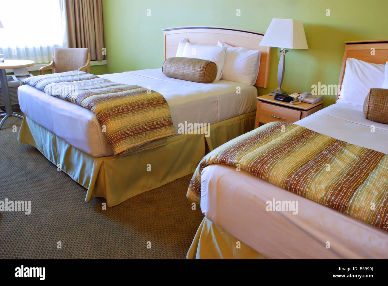 Bed and pillows in a green hotel room Stock Photo