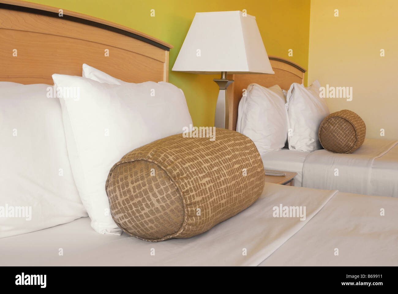 Bed and pillows in a green hotel room Stock Photo