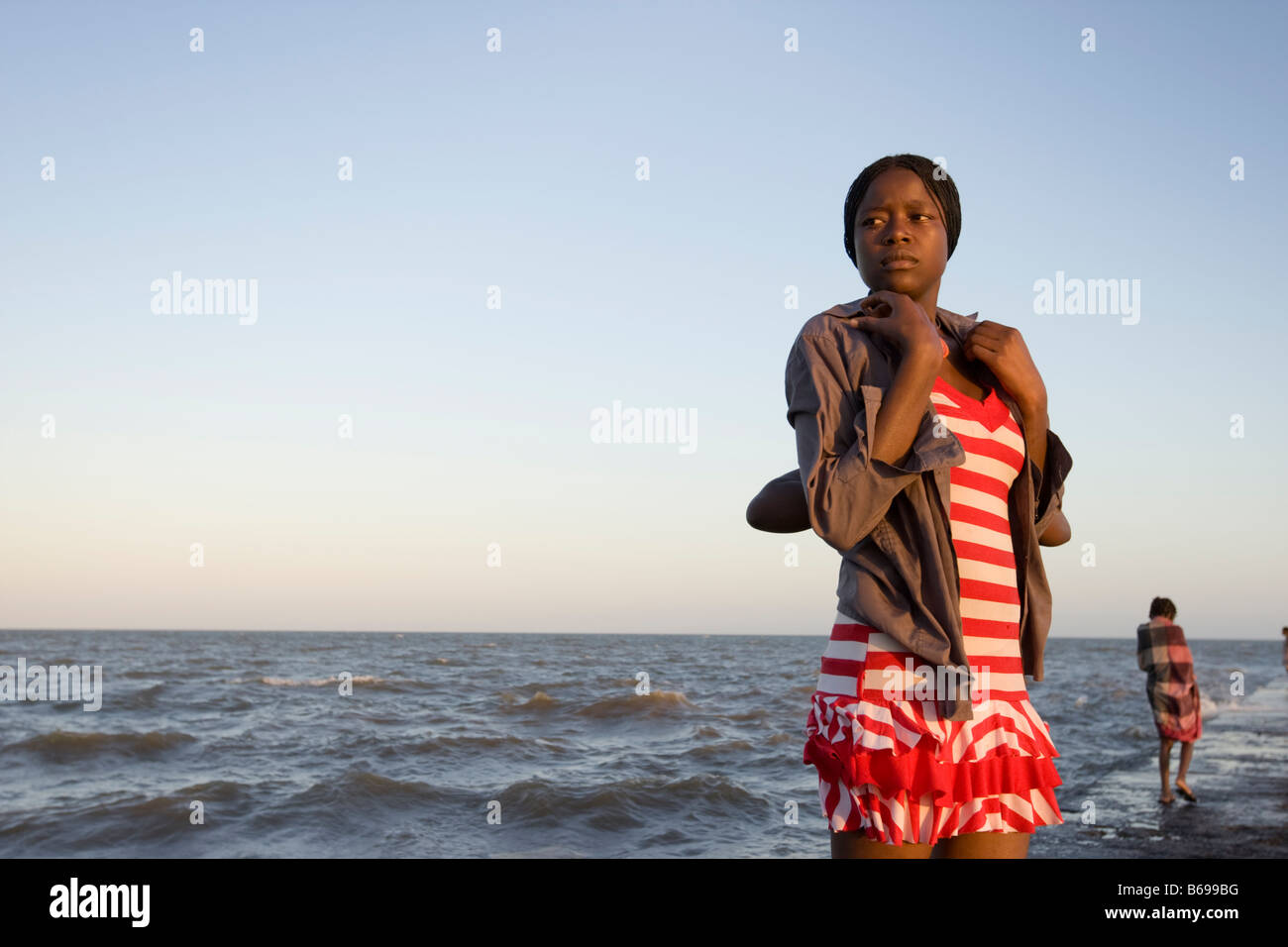 Africa Mozambique Maputo Portrait of young woman standing on jetty along Indian Ocean at sunset Stock Photo