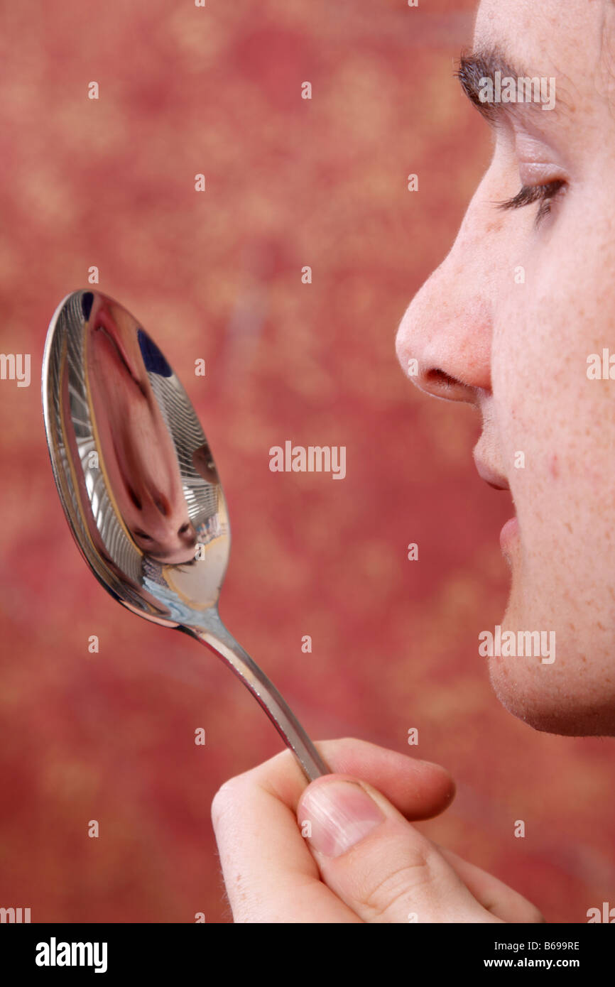 teen looking at his reflection in a spoon Stock Photo Alamy