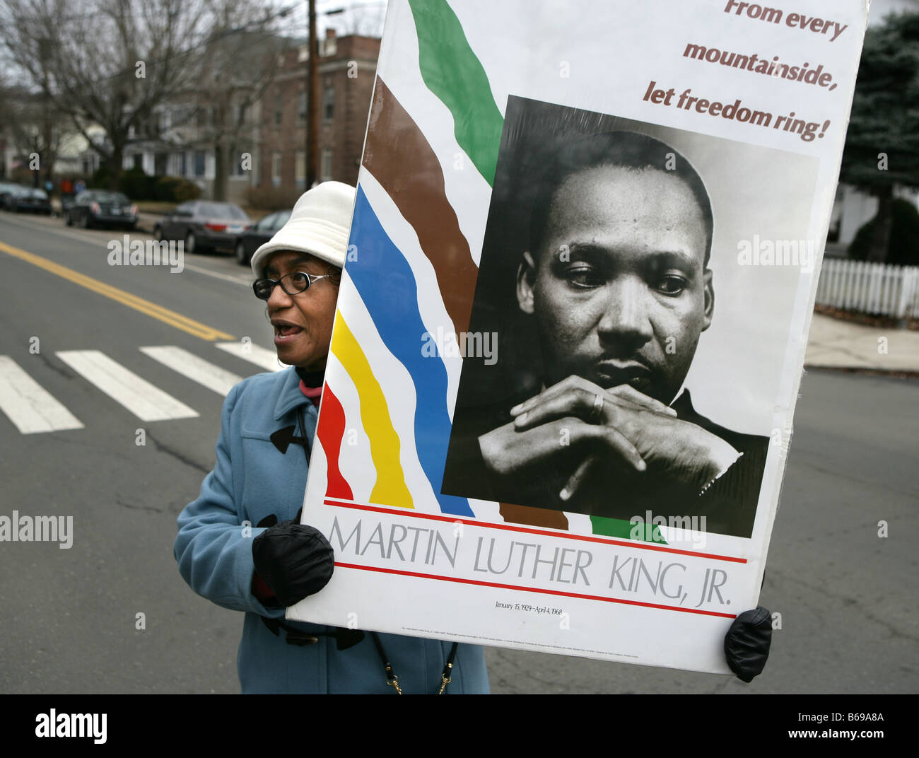 A woman holds a Dr. Martin Luther King poster during a parade during Martin Luther King Holiday in the USA. New Haven, CT. Stock Photo