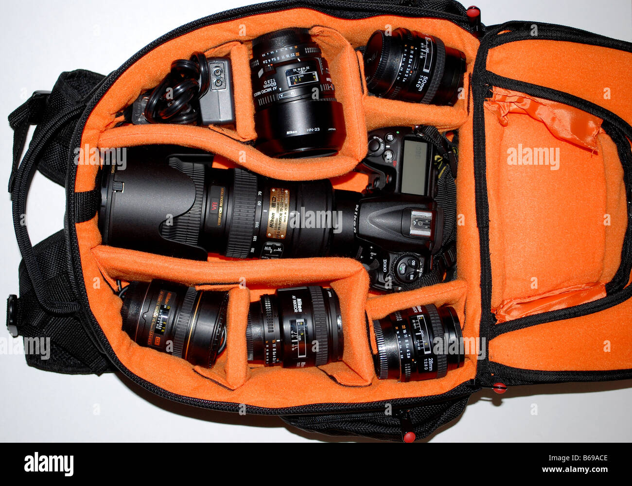 A camera bag, perfectly organized, filled with Nikon photography equipment, telephoto lenses, flash, cables, camera body. Stock Photo
