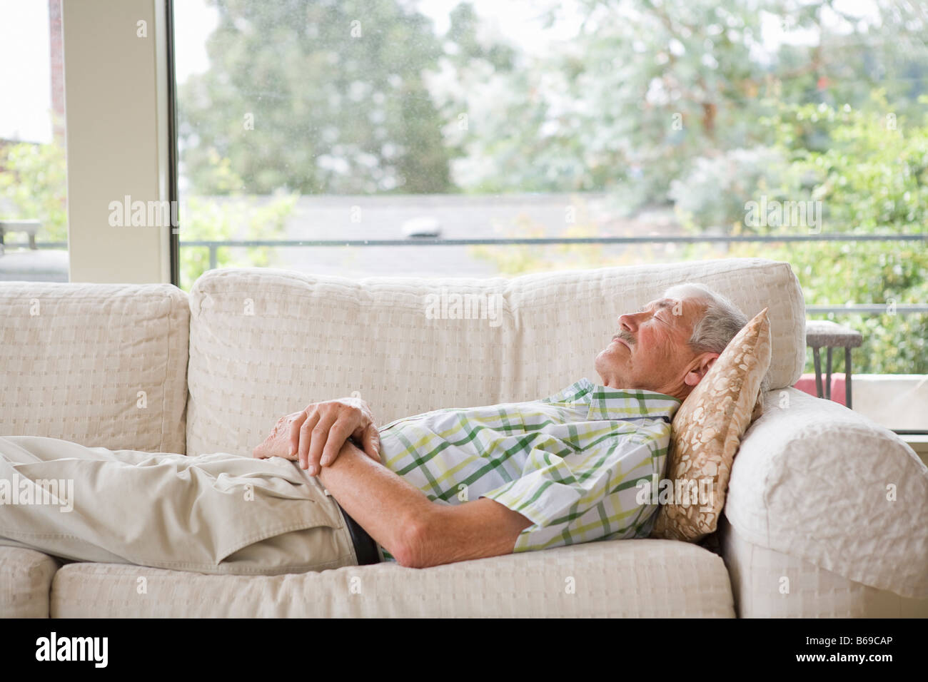 Man napping on a couch Stock Photo Alamy