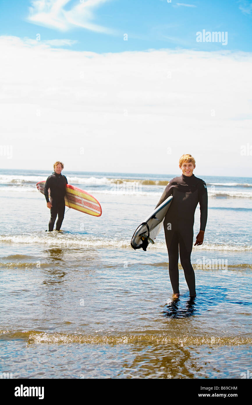 Surfers holding surfboards on the beach, Washington State, USA Stock