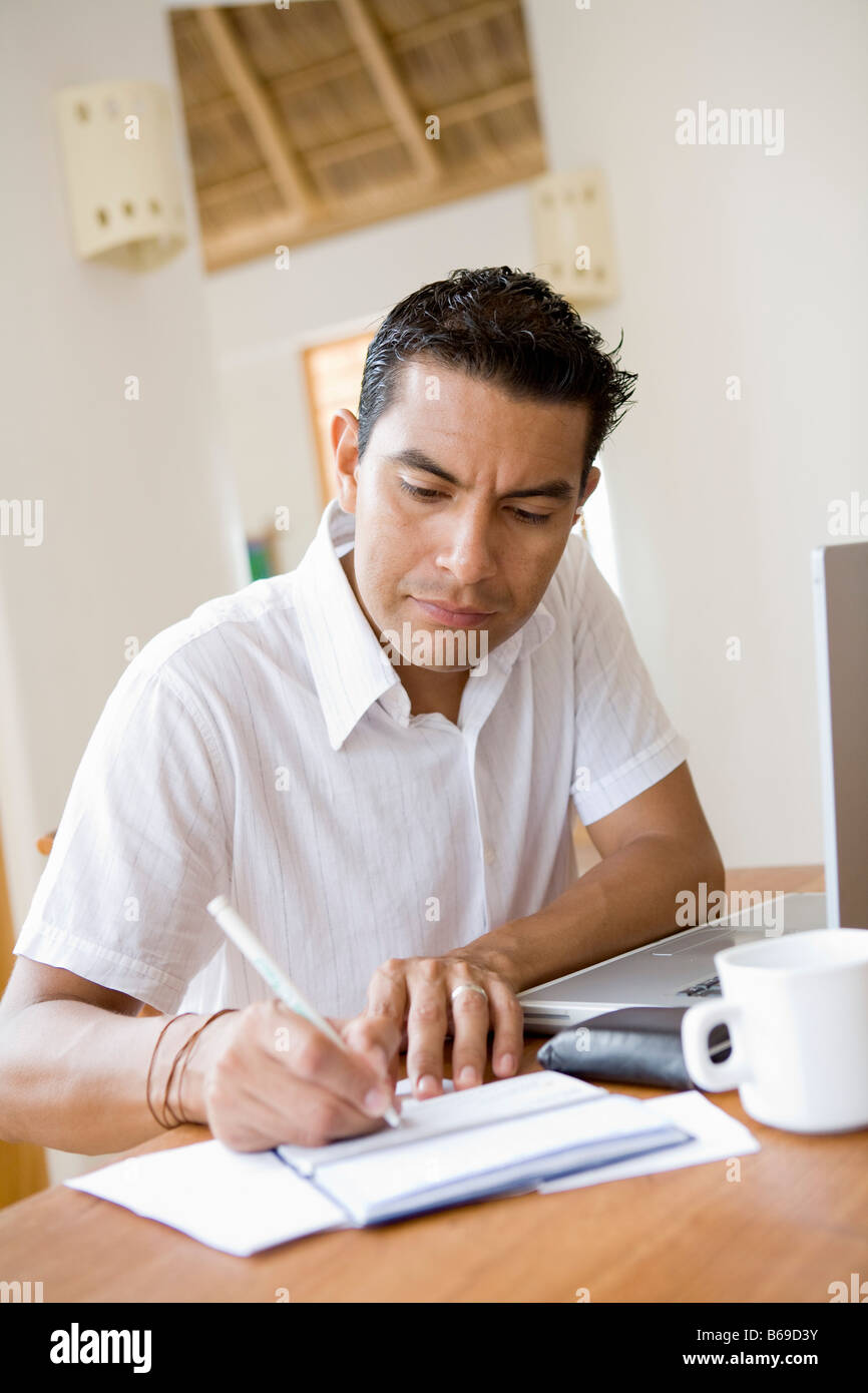 Man working on a laptop and preparing home finance budget Stock Photo