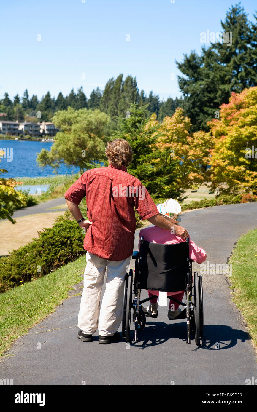 Man assisting his disabled mother in a wheelchair Stock Photo Alamy