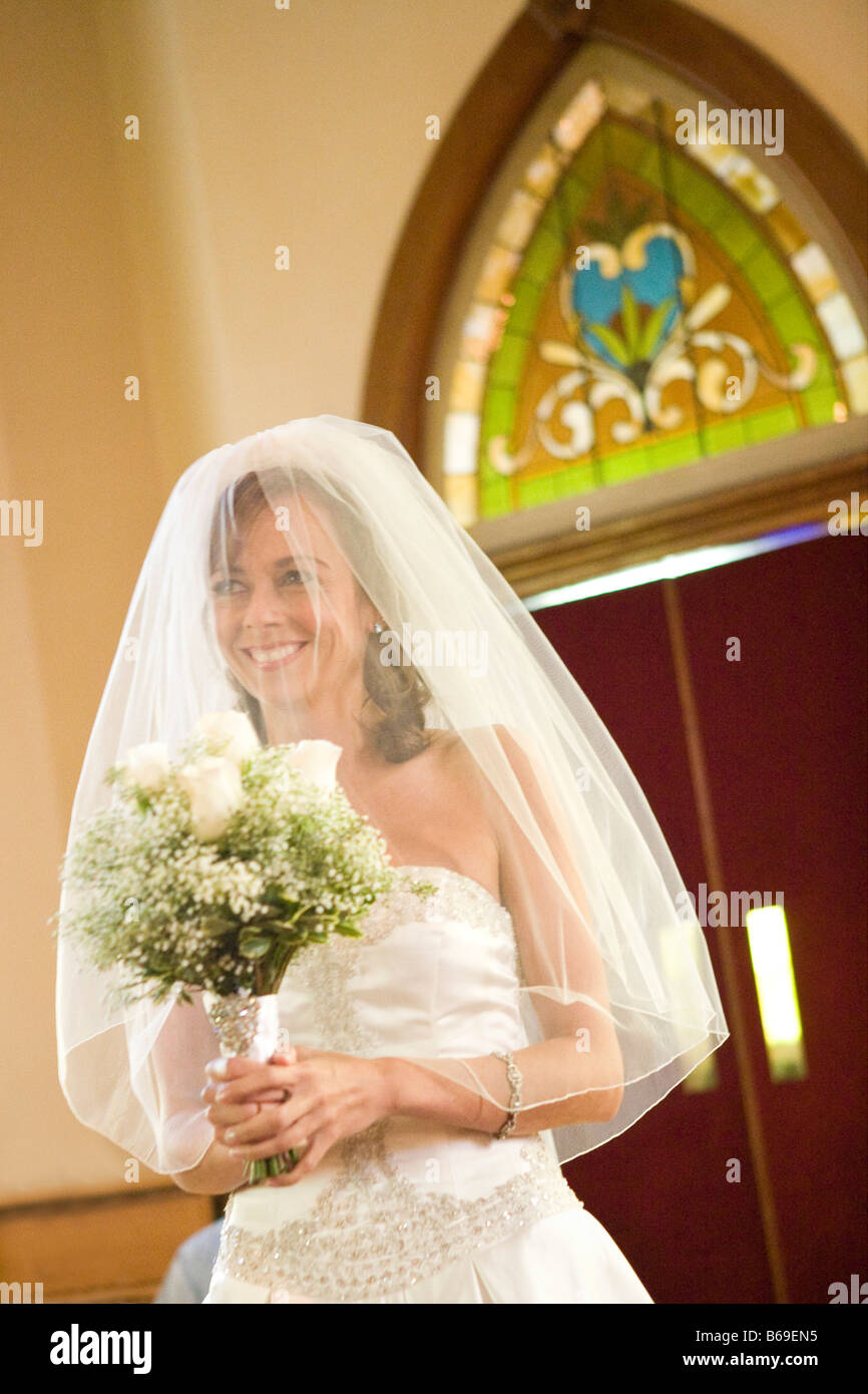 Bride holding a bouquet of flowers in a church, East Meredith, New York State, USA Stock Photo