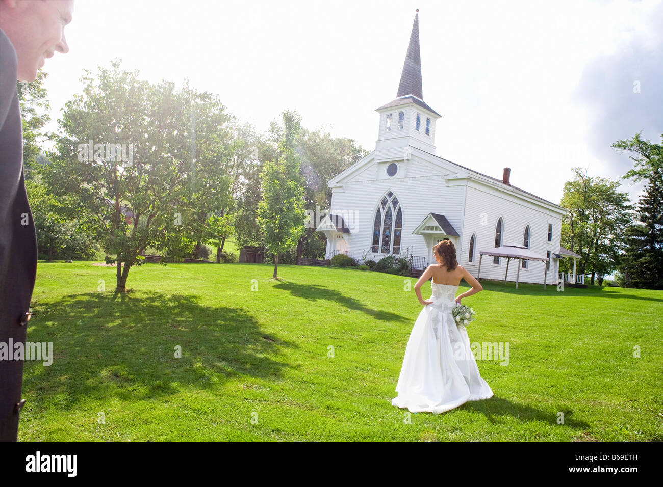 Bride standing near a church, East Meredith, New York State, USA Stock
