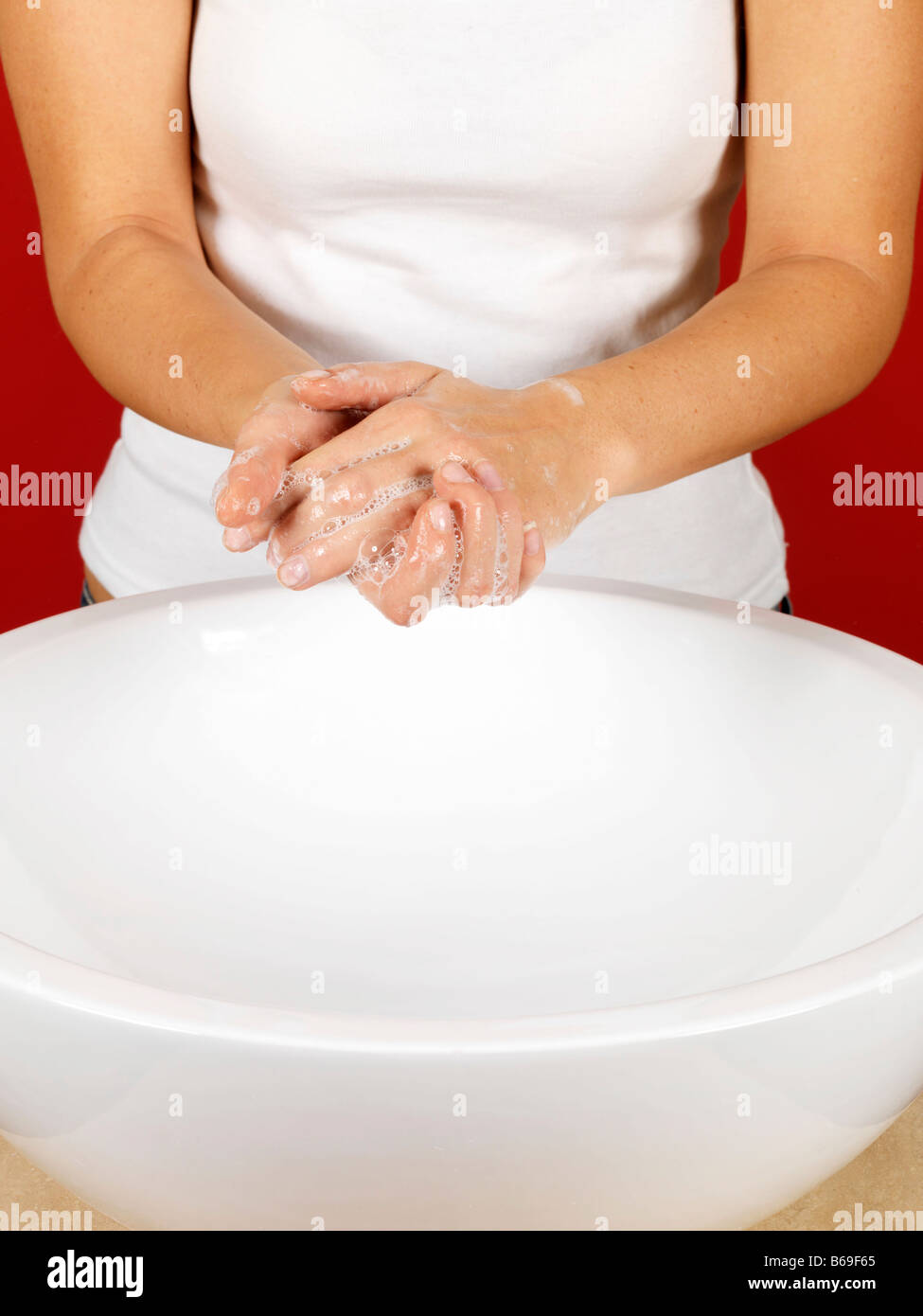 Hygienic Young Woman Washing Her Hands In A Bathroom Sink With Soap And ...