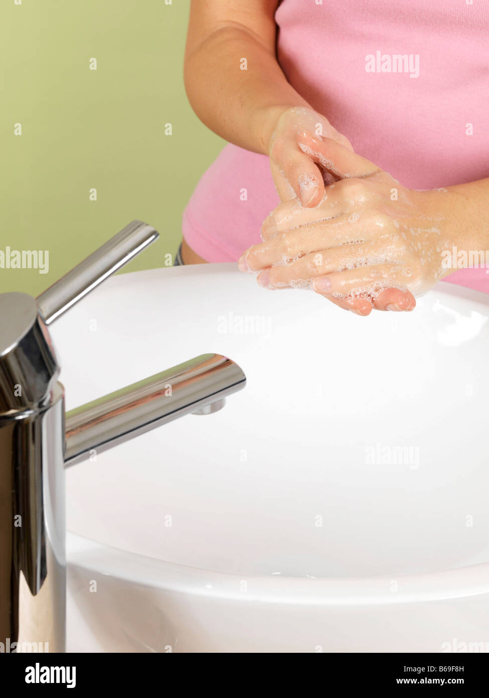 Hygienic Young Woman Washing Her Hands In A Bathroom Sink With Soap And ...