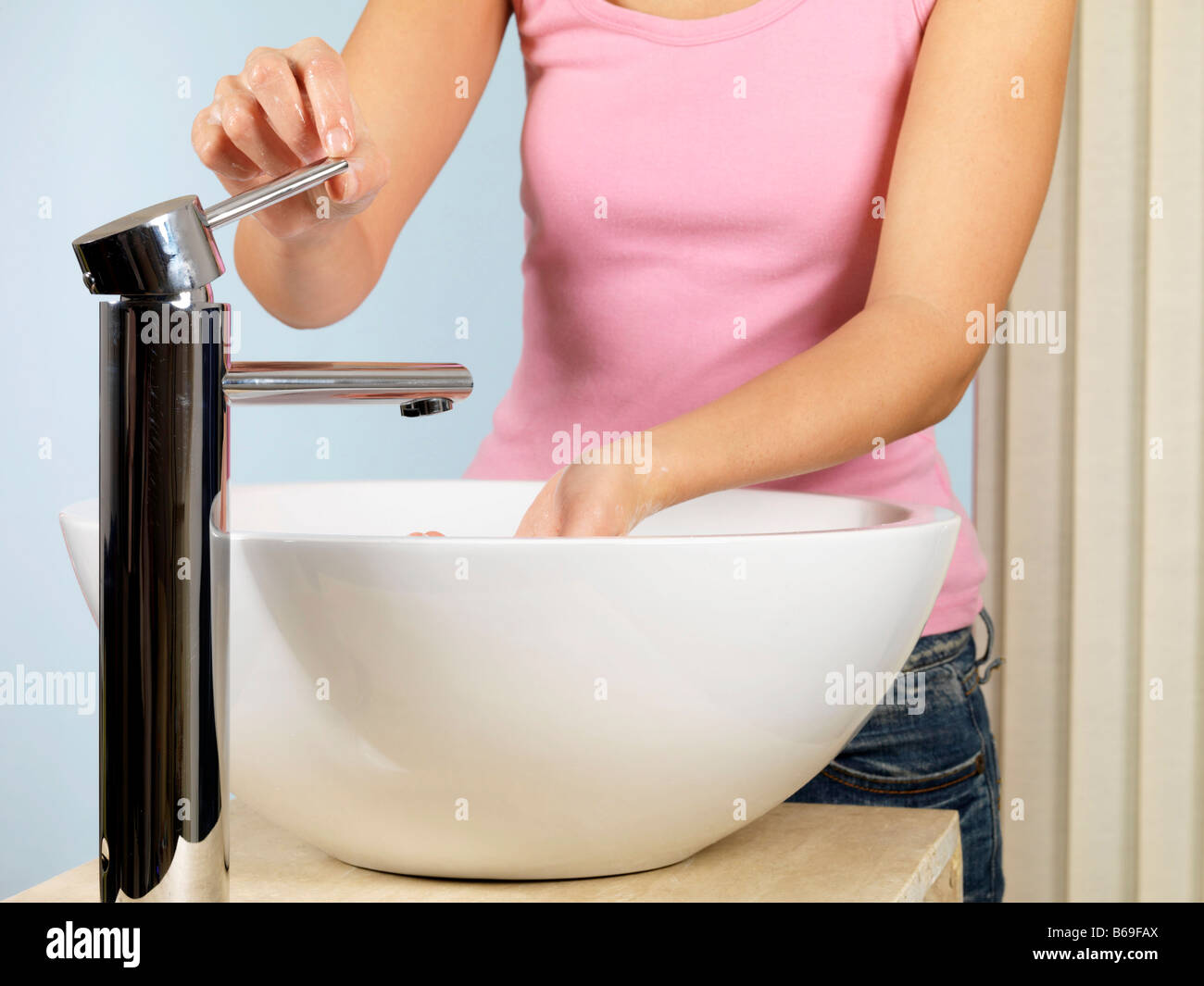 Hygienic Young Woman Washing Her Hands In A Bathroom Sink With Soap And ...