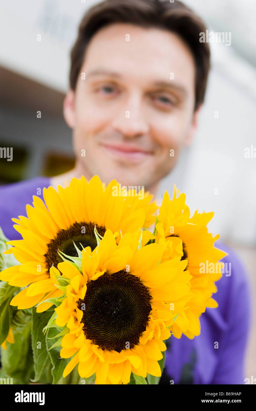 Man giving flowers to the viewer Stock Photo Alamy