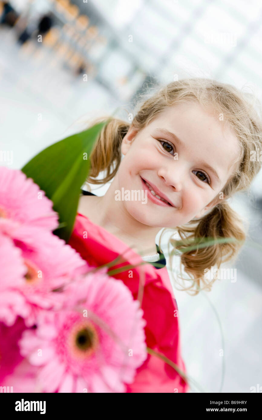 Girl smiling holding flowers Stock Photo - Alamy