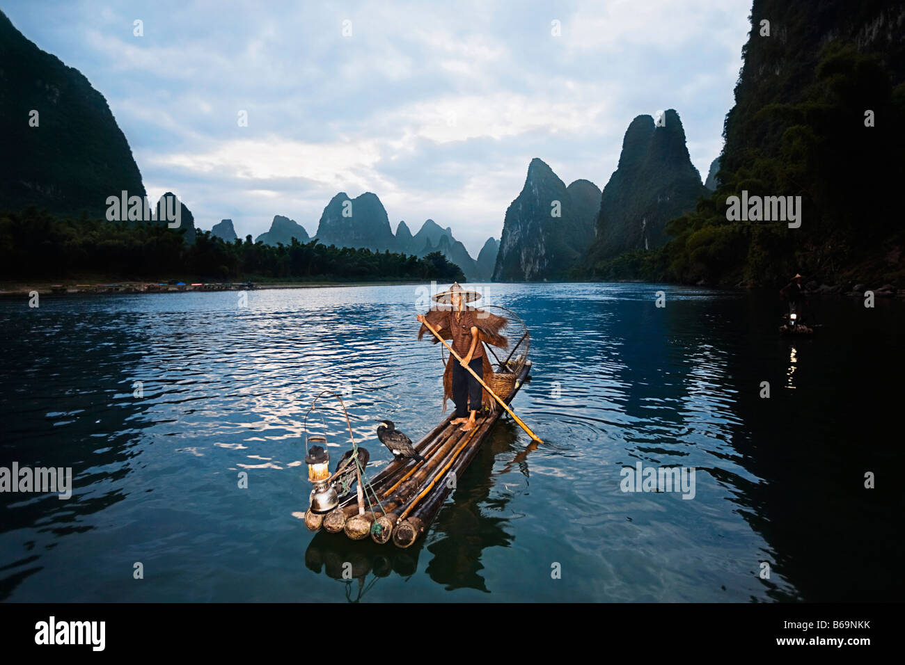Fisherman standing on a wooden raft in a river, Li River, XingPing, Yangshuo, Guangxi Province, China Stock Photo