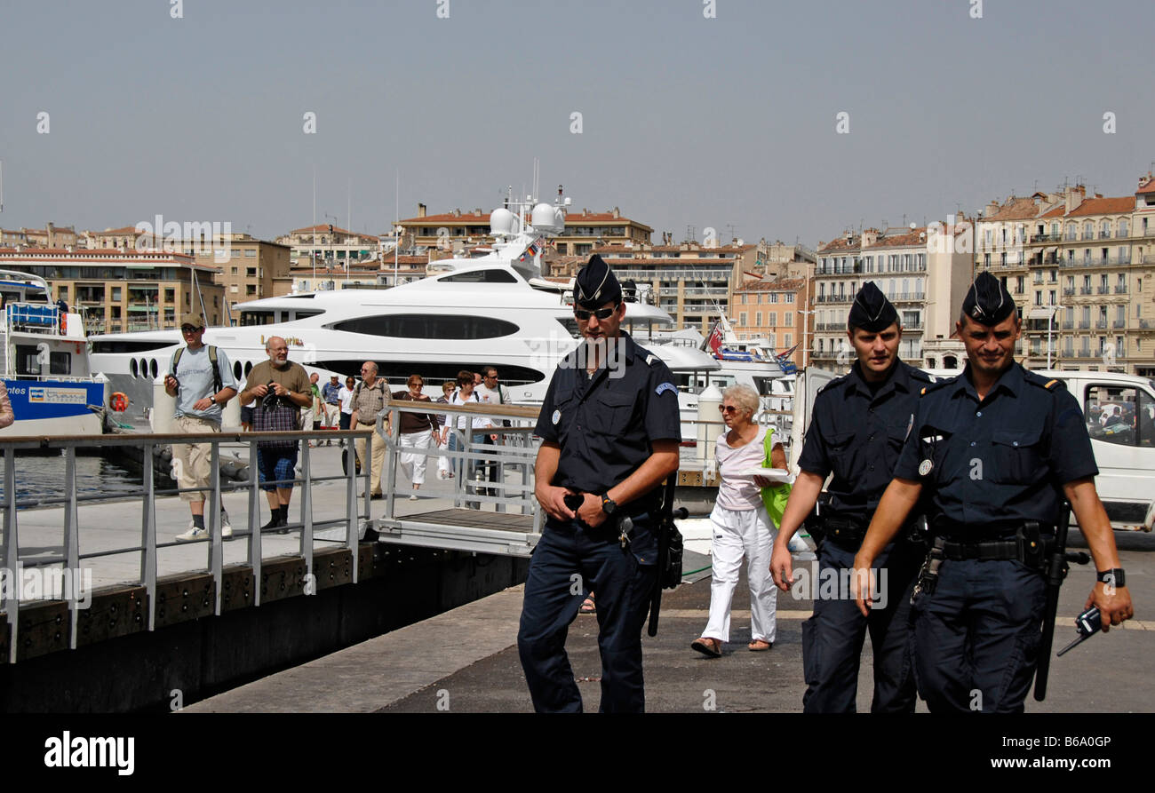 Three french police officers walking along harbour, Marseille, France, Europe Stock Photo