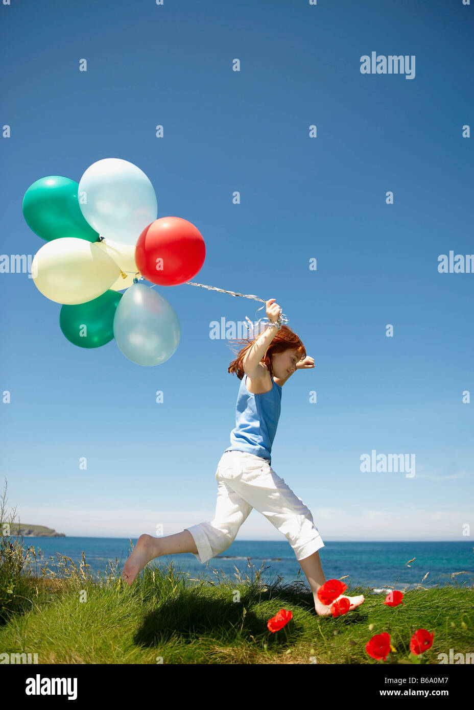 Young girl running with balloons Stock Photo - Alamy