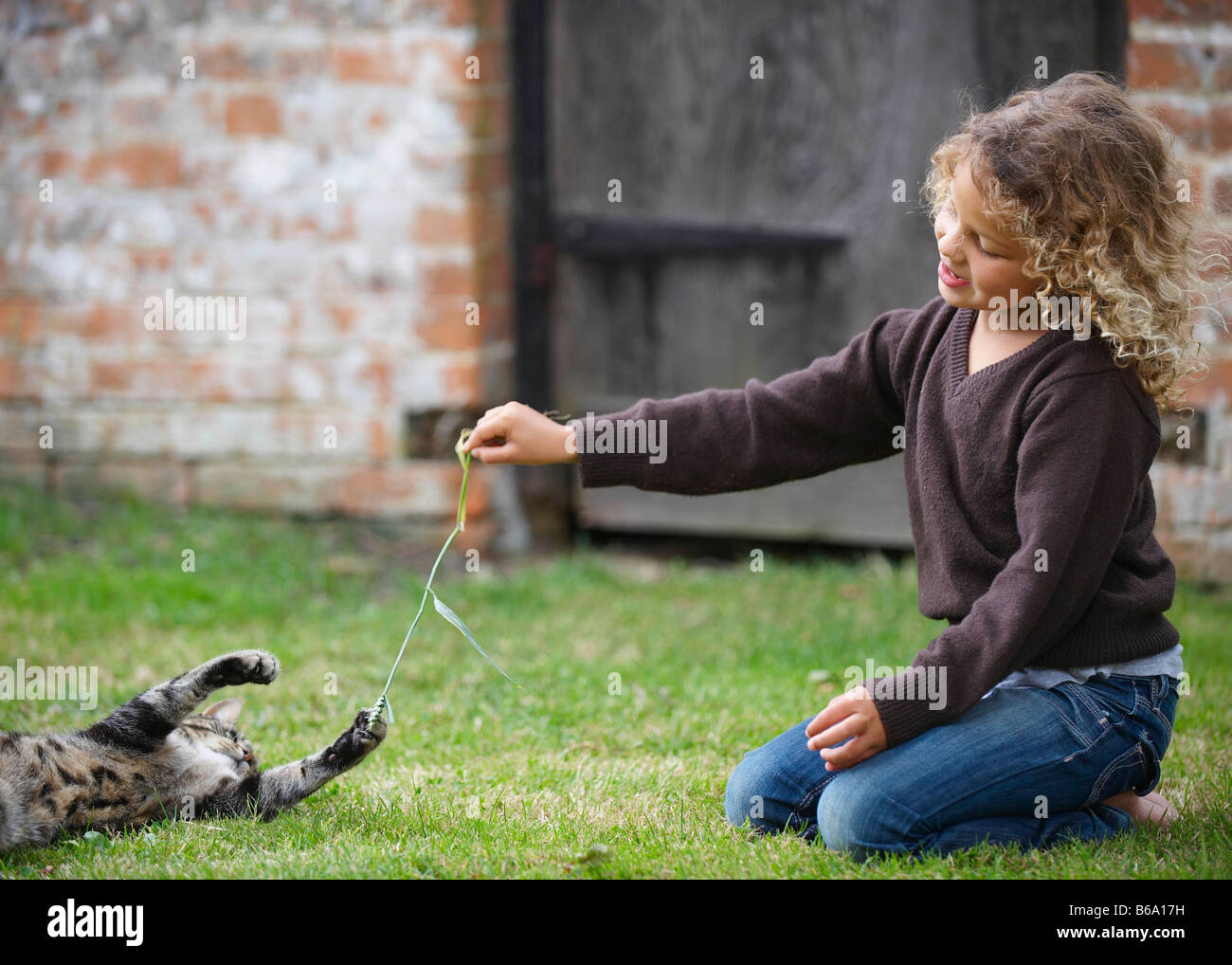 Young girl playing with cat outside Stock Photo - Alamy