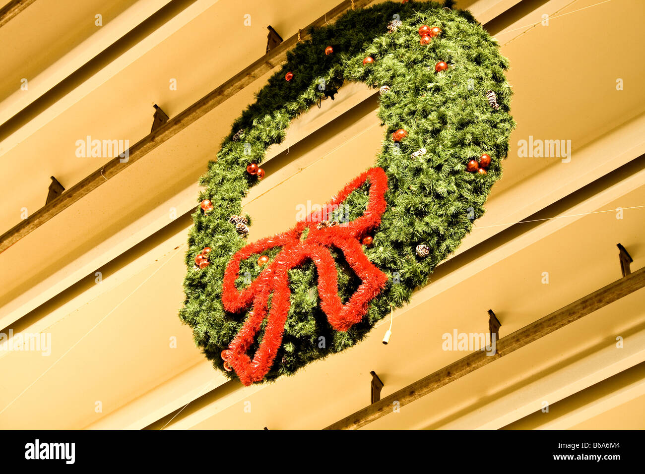 Large Christmas Wreath With A Red Bow Hanging High Up On A