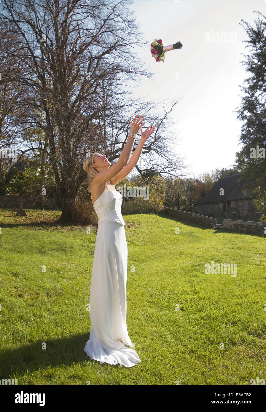 A bride throwing her bouquet of roses Stock Photo Alamy