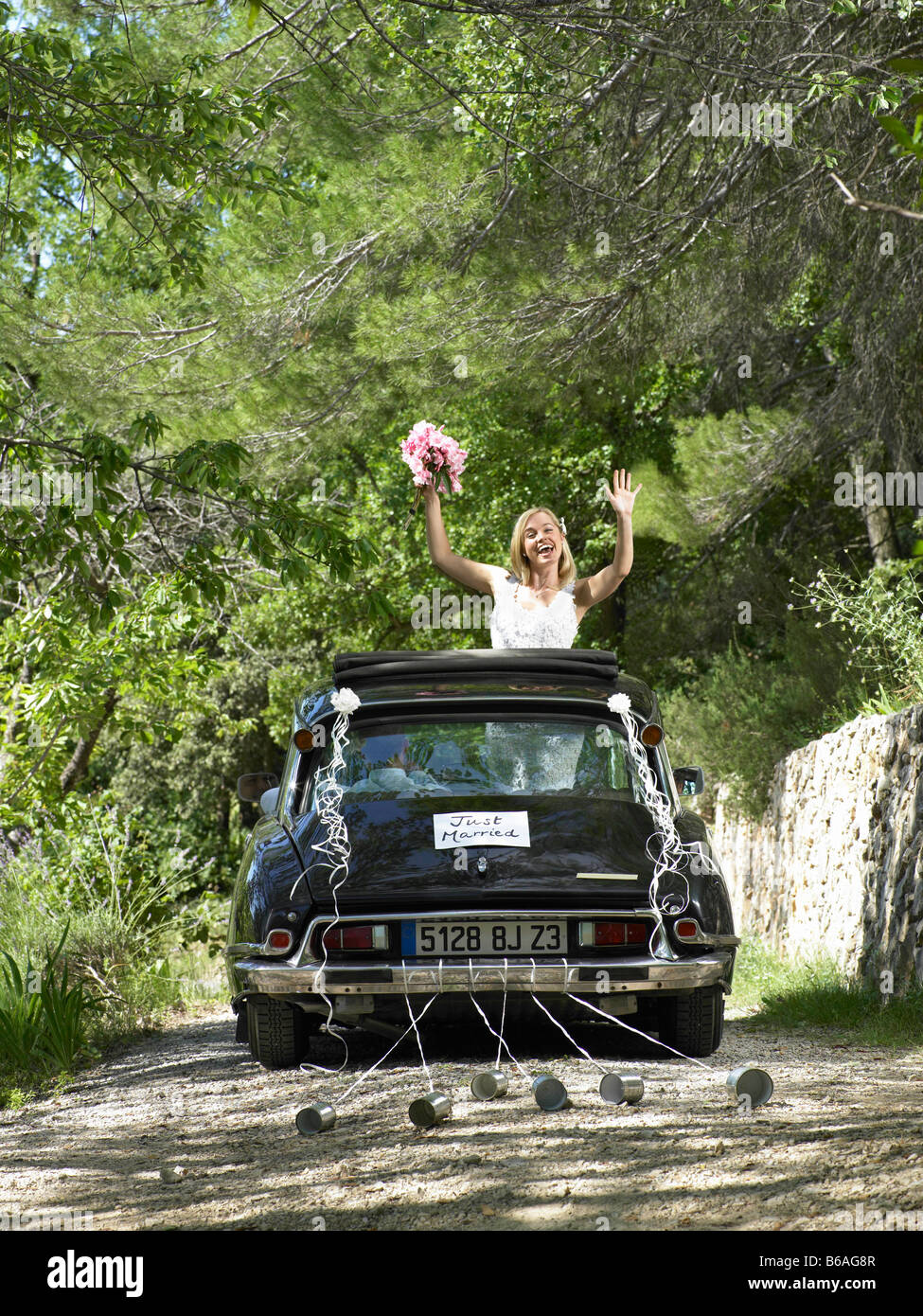 Bride waving from wedding car Stock Photo - Alamy