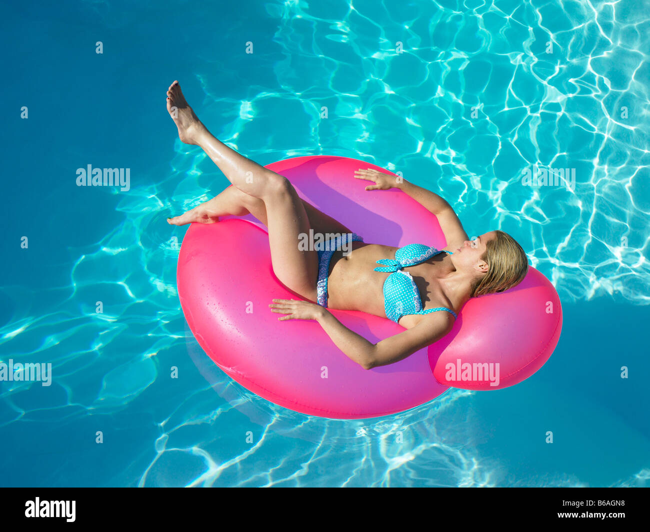 Woman on inflatable chair in pool Stock Photo