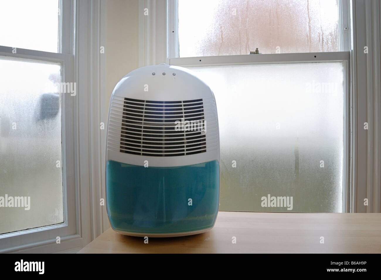 Dehumidifier in front of condensation on windows Stock Photo