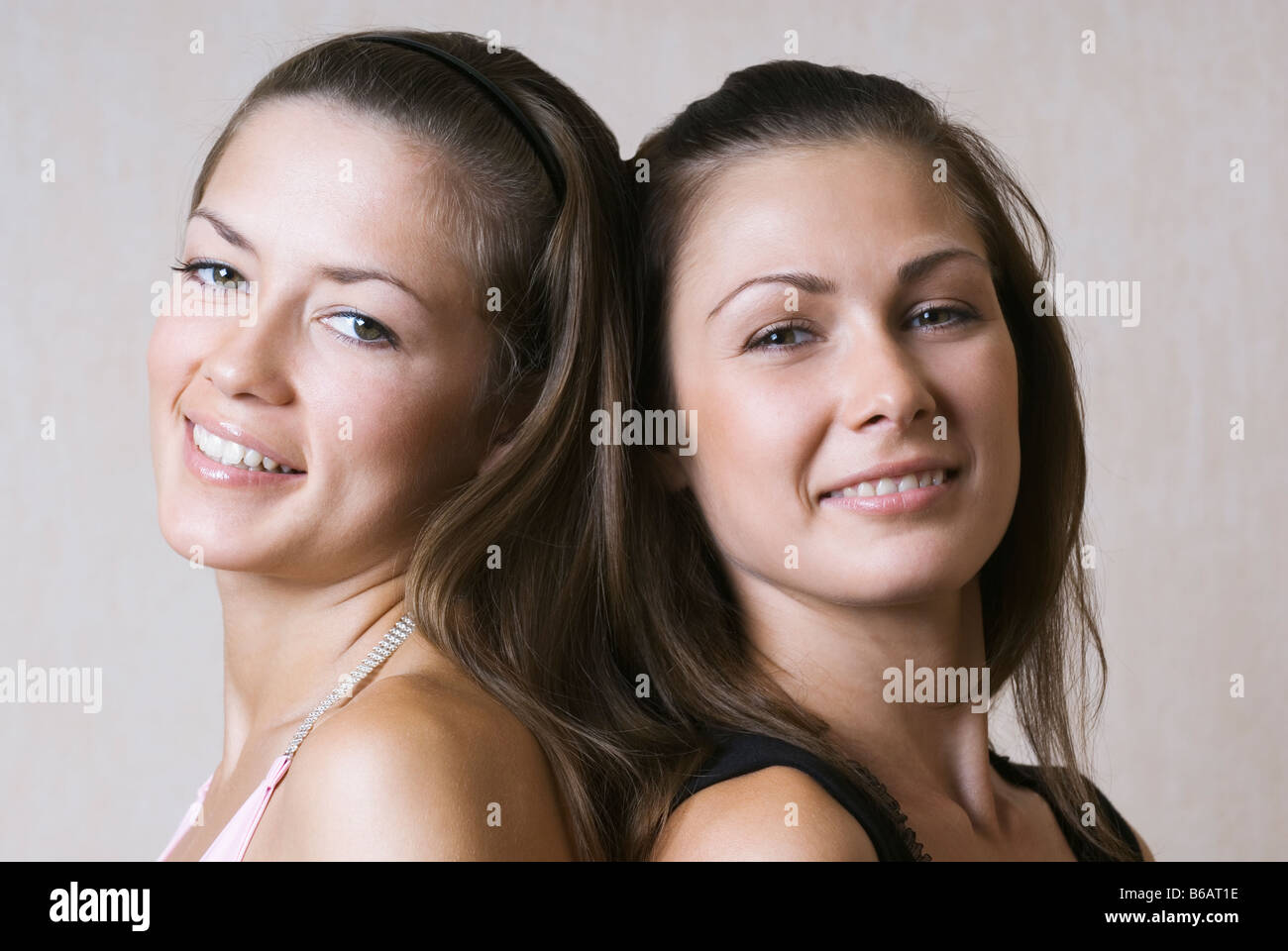 Portrait of two young women back to back Stock Photo