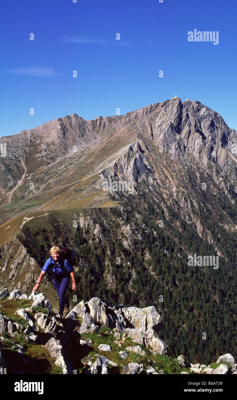 Female walker nearing the summit of Monte Berlinghera near Sorico, Lombardy, Italy. Stock Photo