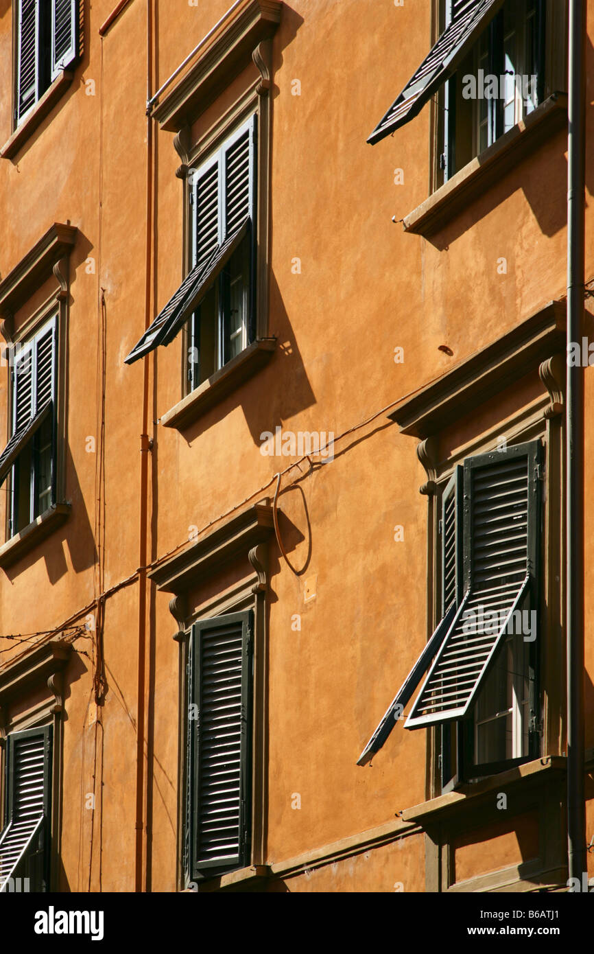 Green-shuttered windows on orange rendered building in Pisa, Florence. Stock Photo