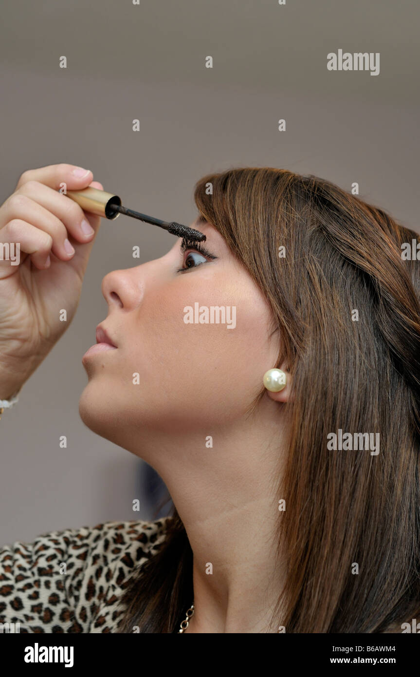 Brunette teenage girl applying mascara. Closeup. Stock Photo