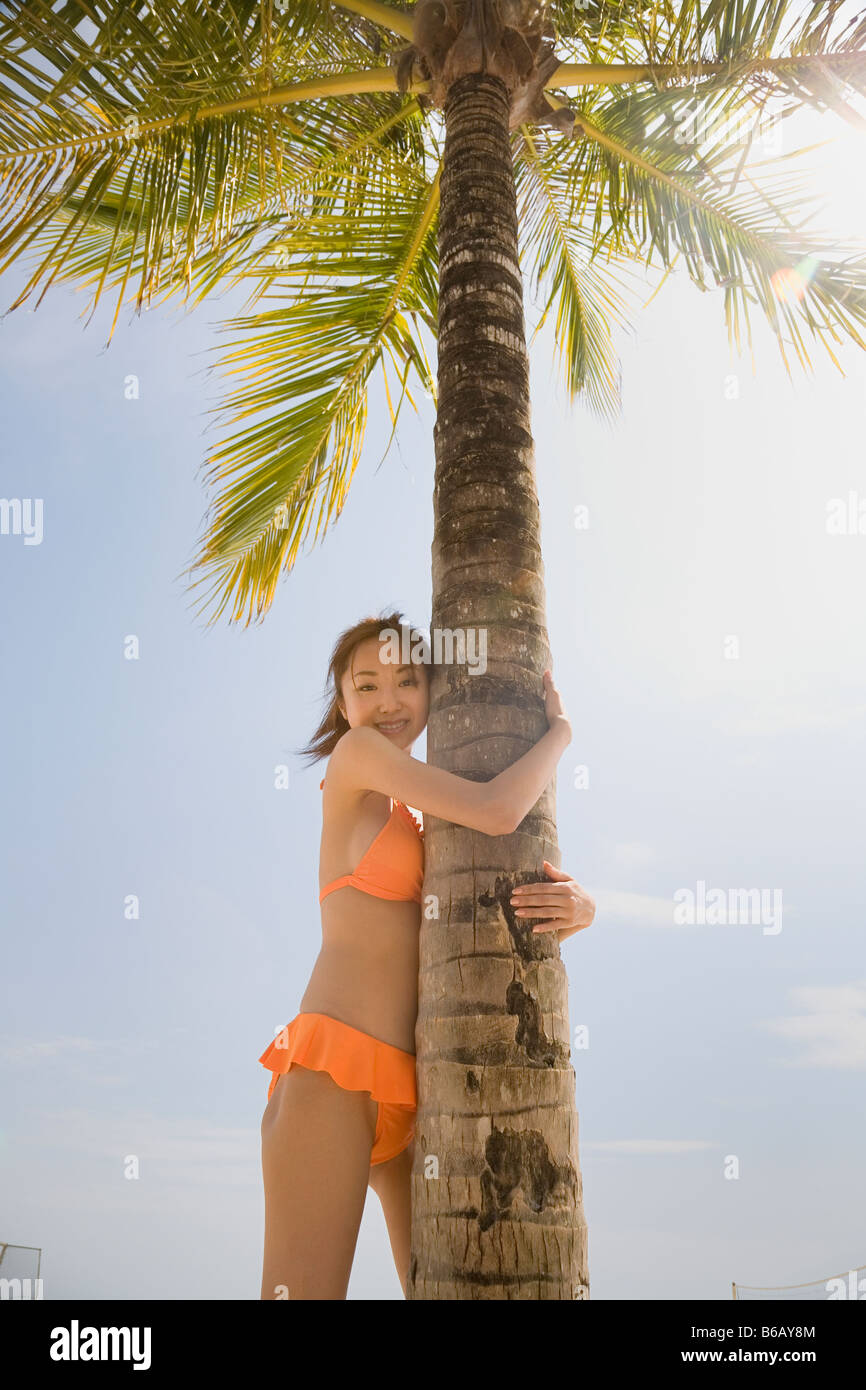 Young woman in bikini holding palm tree Stock Photo Alamy