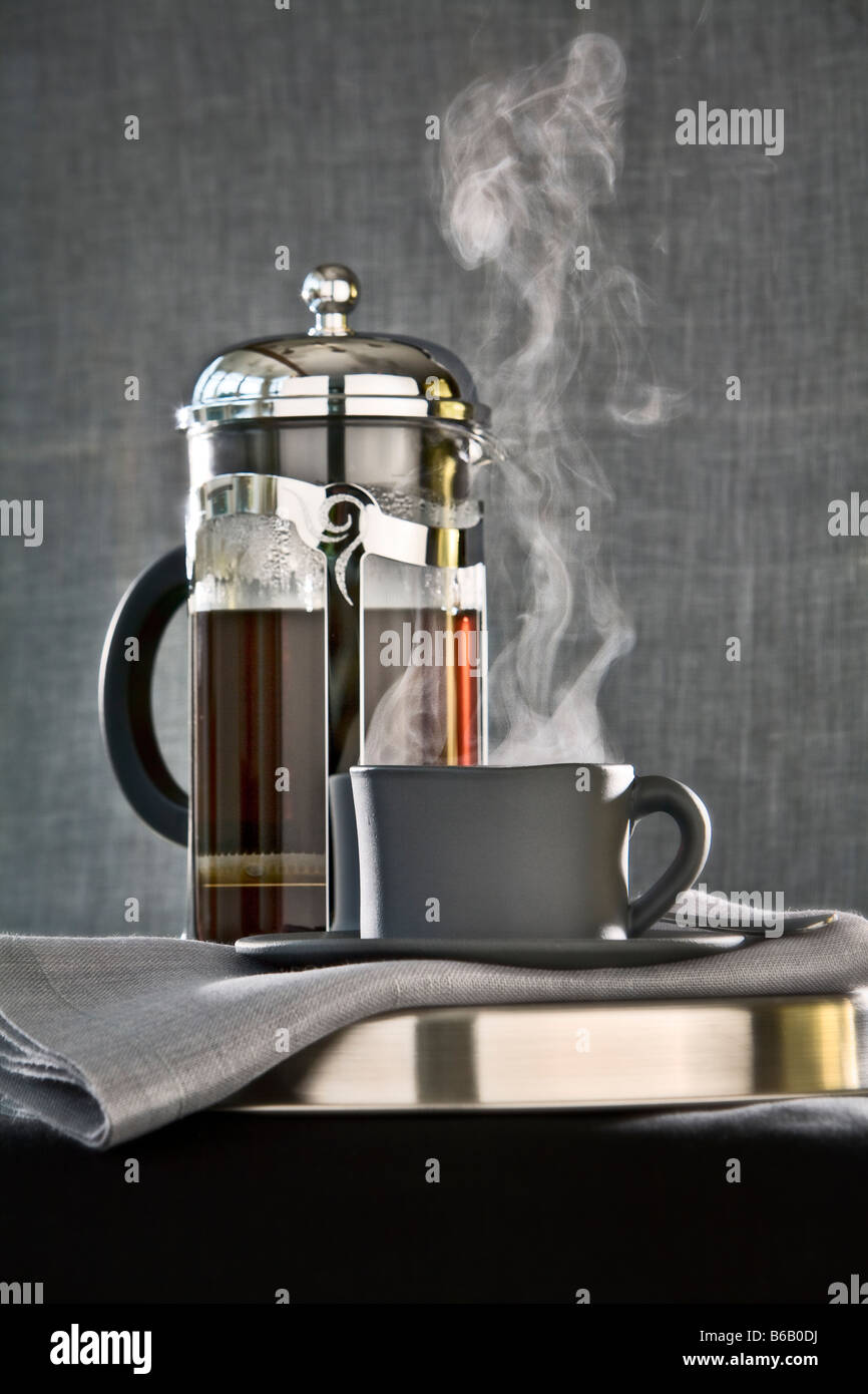 steaming cup of coffee with French coffee press pot Stock Photo Alamy