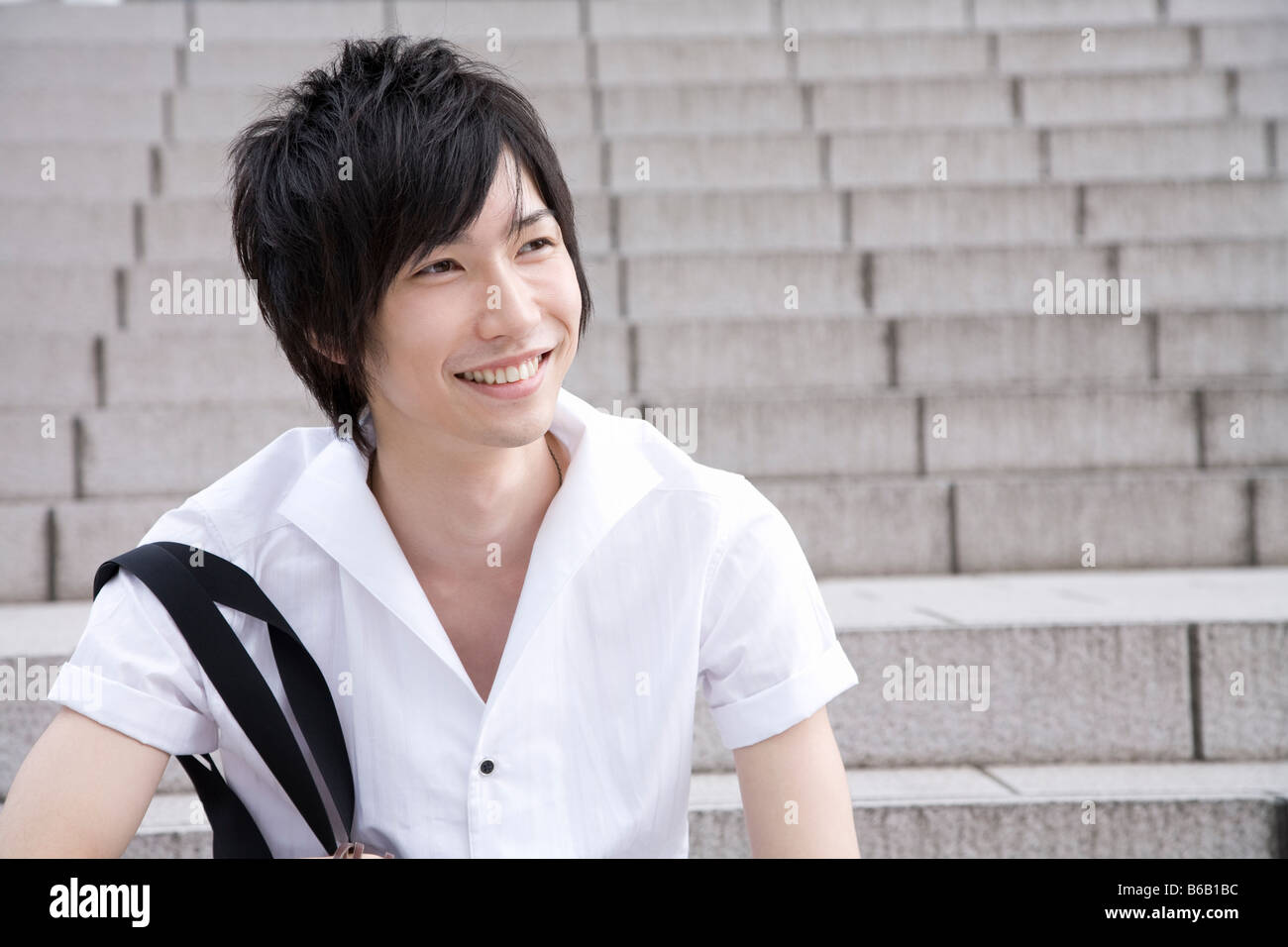 Young man sitting on steps Stock Photo - Alamy