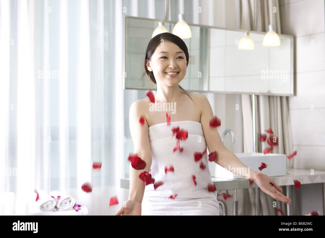 Young woman wrapped in a towel and smiling Stock Photo - Alamy