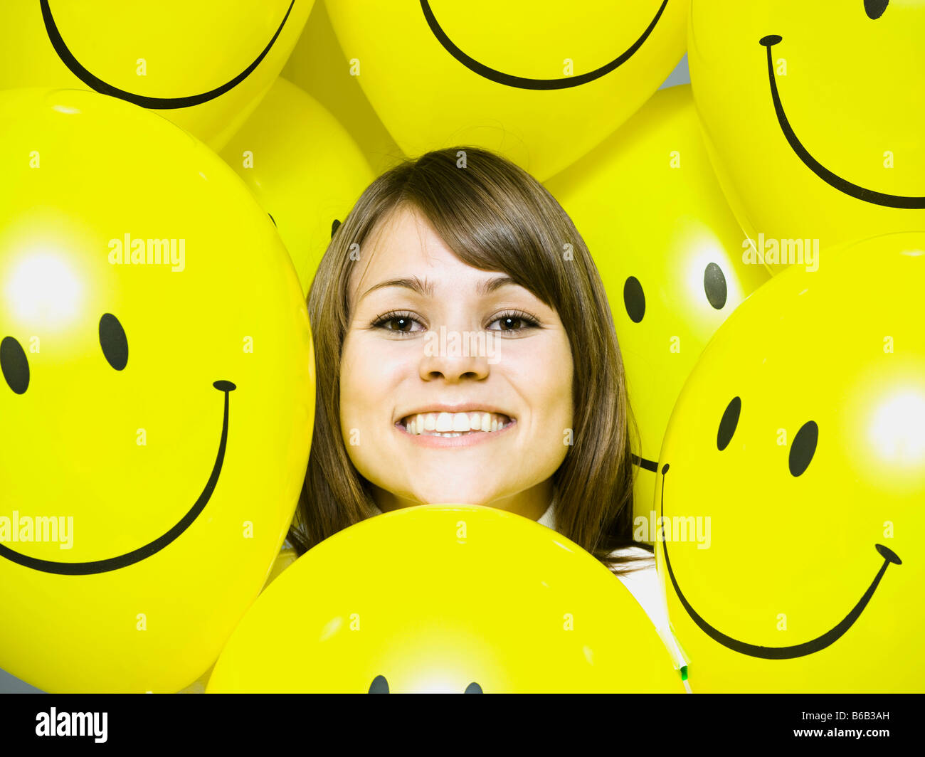 woman with smiley face balloons Stock Photo