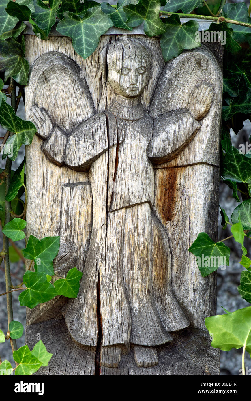 angel sculpture wooden statue with spread wings and ivy Stock Photo