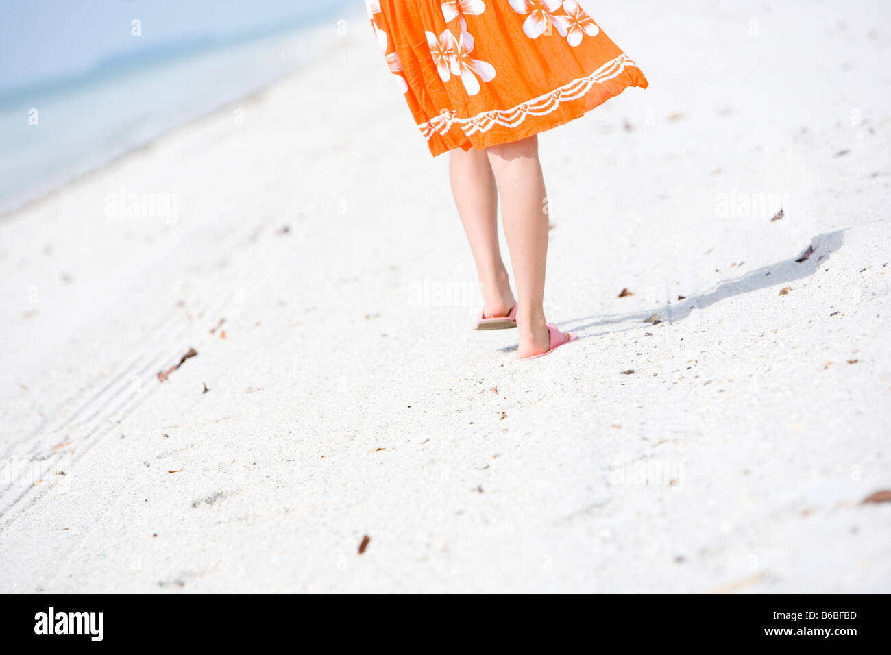Legs of young woman walking at beach Stock Photo