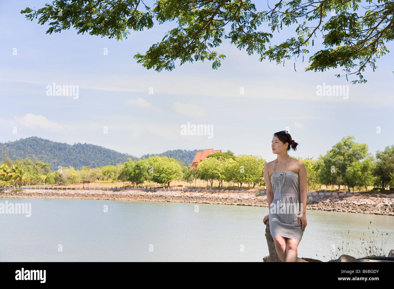 Young woman sitting at beach Stock Photo - Alamy