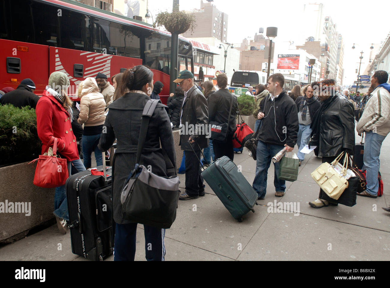 Travelers wait on line to board the economically priced MegaBus outside of Pennsylvania Station in New York Stock Photo