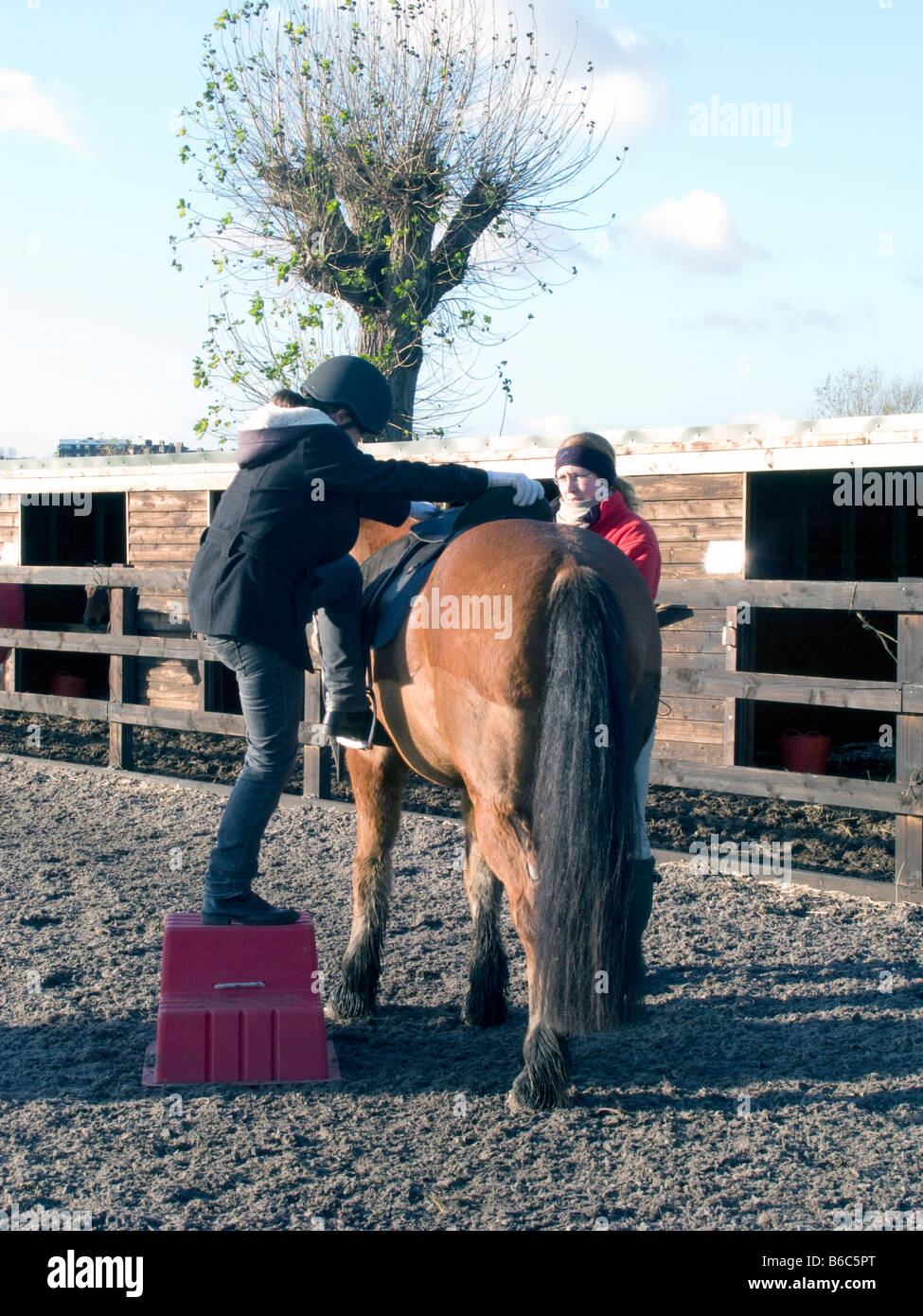 AN INSTRUCTOR TEACHING SCHOOL CHILDREN TO RIDE AT A RIDING SCHOOL LONDON, UK. Photo ©Julio Etchart Stock Photo