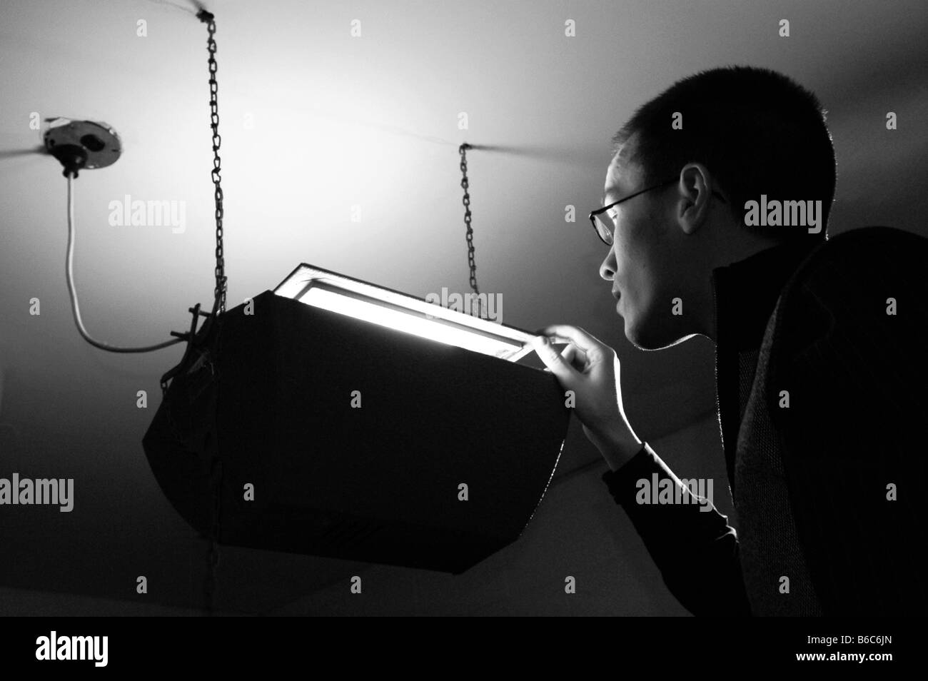 A curious person looks into a glowing box. Stock Photo