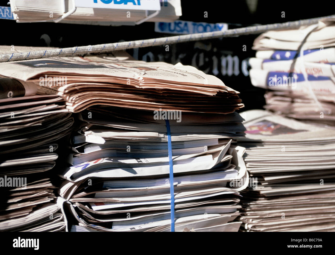 Stacks of bound newspapers waiting for recycling at collection site in New York City Stock Photo