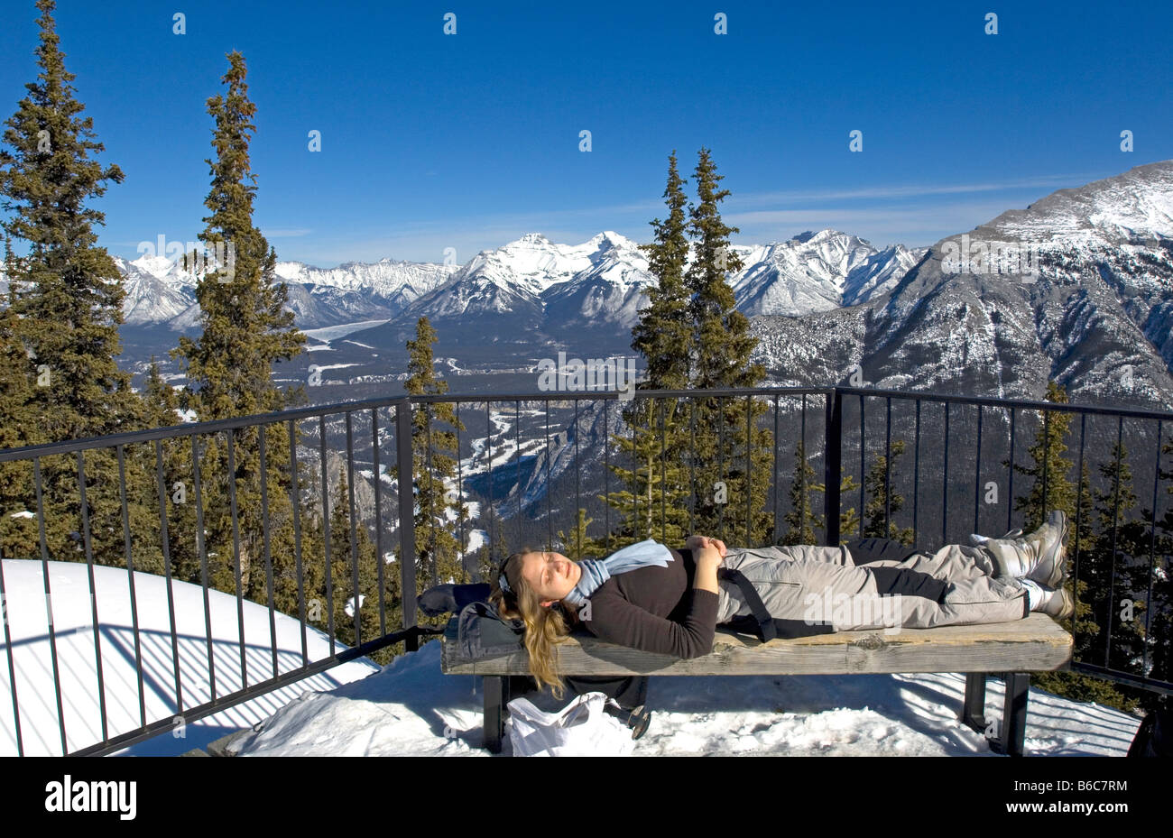 Young woman on bench with views of Banff and the Bow Valley surrounded ...
