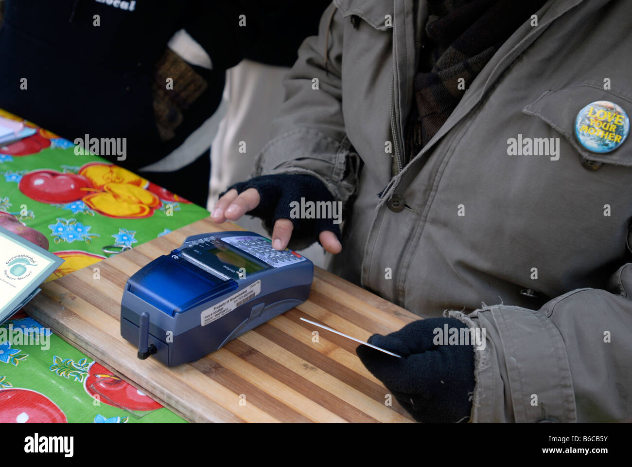 A Greenmarket employee uses an EBT scanner using wireless technology to