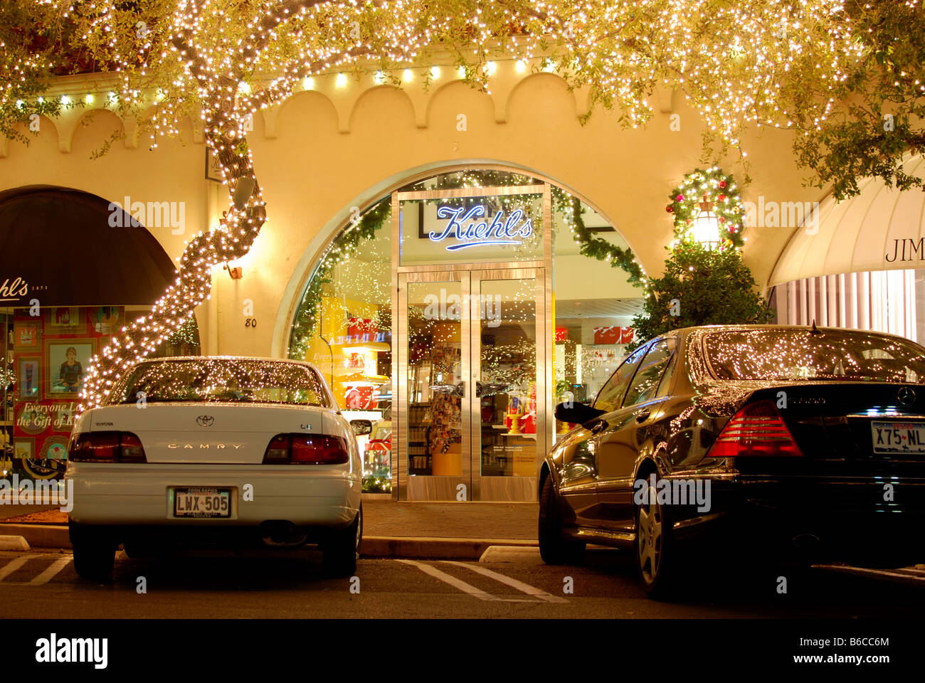 Christmas lights in an expensive shopping center with cars parked in