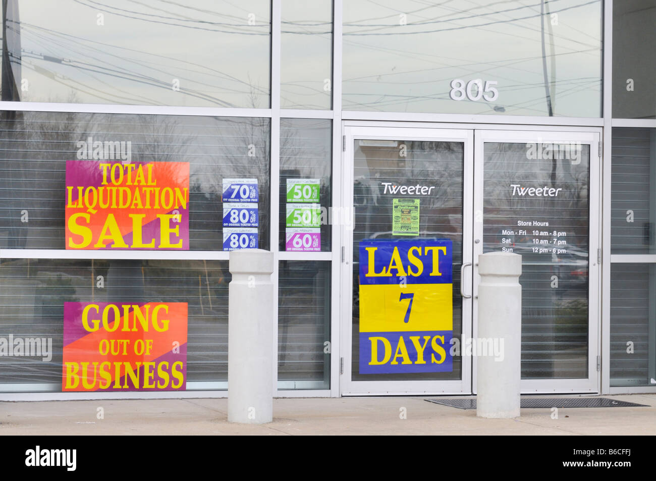 Empty  closed retail store with liquidation sale signs in windows. Stock Photo