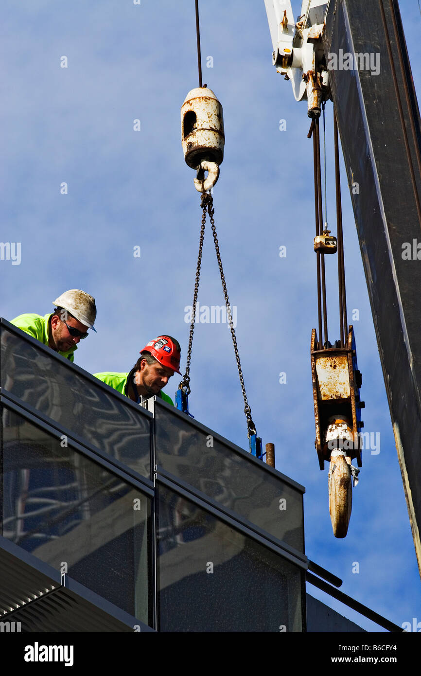 Construction / Construction workers fit a facade section being lifted by a site crane.Melbourne Victoria Australia. Stock Photo